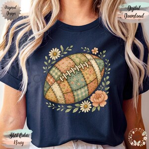 May include: Navy blue t-shirt featuring a floral patchwork football design. The football is surrounded by a wreath of flowers and leaves. The shirt has the text "Original Design" and "Digital Download". The shirt color is navy.