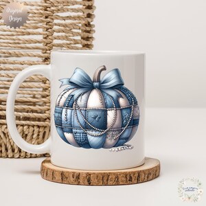 May include: White ceramic mug with a blue and white patchwork pumpkin design, a bow, and pearl accents. The mug sits on a wooden coaster. The words "Original Design" are printed on the top left of the mug.
