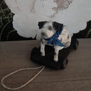 Super süße Baumwollpuppe. Hund mit Punkten und blauer Schleife auf einem Wagen mit Rädern. Brocante Vintage-Spielzeug, SpunCotton Cotton Cotton Doll