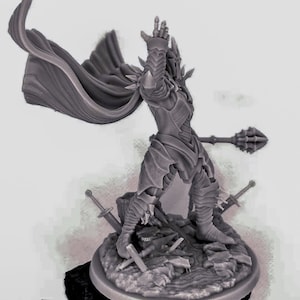 Puede incluir: Una figura en miniatura gris y detallada de un guerrero que lleva armadura y una capa fluida, sosteniendo una maza con púas. La figura está de pie sobre una base con espadas rotas y escombros.