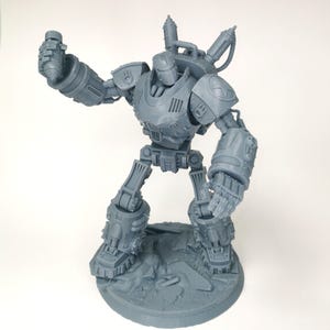 Pode incluir: Um modelo cinza, detalhado, impresso em 3D de um robô com estética steampunk. O robô tem uma cabeça grande e redonda com uma placa facial e um corpo grande e cilíndrico. O robô segura uma arma em sua mão direita e tem um braço mecânico grande em seu lado esquerdo.