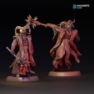 Puede incluir: Dos figuras de fantasía detalladas de figuras con túnicas, cascos con cuernos y báculos ornamentados. Las figuras son de color marrón rojizo, de pie sobre bases circulares. La imagen tiene el logotipo "NAVARRETE studio".