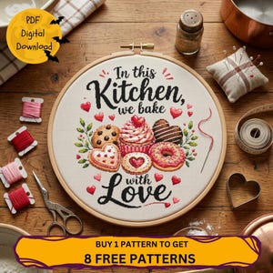 Peut inclure: Un tambour à broder en bois rond contenant un motif au point de croix sur tissu blanc. Le design présente le texte noir In this Kitchen, we bake with Love, entouré de biscuits, d'un cupcake et d'un donut brodés avec des cœurs rouges.