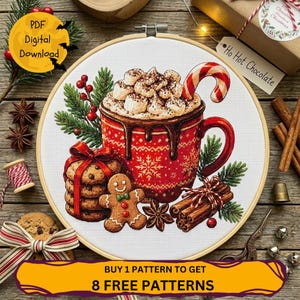 May include: A cross-stitch pattern in a wooden embroidery hoop featuring a red mug filled with hot cocoa, marshmallows, and a candy cane. The design includes a stack of cookies with a red bow, a gingerbread person, cinnamon sticks, and pine.