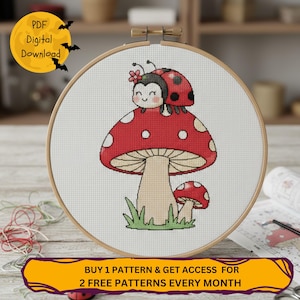 Könnte beinhalten: Kreuzstich-Stickerei in einem Holzrahmen. Das Design zeigt einen roten Pilz mit weißen Punkten und einen lächelnden Marienkäfer. Der Text "PDF Digital Download" befindet sich oben links. Der Text "BUY 1 PATTERN & GET ACCESS FOR 2 FREE PATTERNS EVERY MONTH" ist unten.