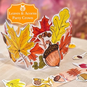 Op de afbeelding: Een feestkroon met kleurrijke herfstbladeren en eikels. De kroon heeft een decoratief ontwerp met rode, gele en oranje bladeren, samen met een grote eikel. De tekst "Leaves & Acorns Party Crown" staat op de kroon.