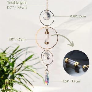 May include: A decorative hanging ornament with a total length of 15.7 inches. It features a gold-colored metal frame with clear crystal accents and a small glass vial. The ornament includes a faceted crystal pendant and is designed for home decor.