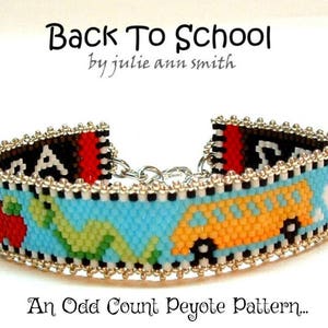May include: A beaded bracelet with a school theme. The bracelet features a light blue background with a yellow school bus, a red apple, and a green dinosaur. The text "Back To School" is at the top.
