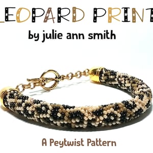 May include: A gold and brown beaded bracelet with a leopard print pattern. The bracelet has a gold clasp and is labeled "LEOPARD PRINT by julie ann smith A Peytwist Pattern".