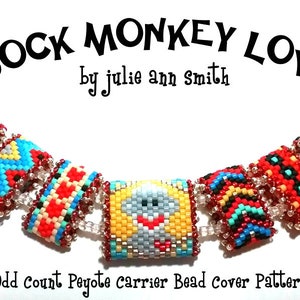 Puede incluir: Un collar de cuentas de colores con un dije de cara de mono. El collar está hecho con cuentas de peyote y tiene una variedad de patrones geométricos en rojo, azul, amarillo y blanco.