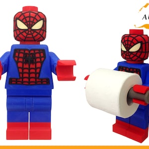 Puede incluir: Un soporte de papel higiénico de Lego Spiderman rojo y azul. La figura tiene un diseño de telaraña negra en el pecho.