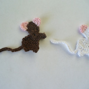 May include: Two crocheted mouse ornaments, one brown with pink ears and one white with pink ears.