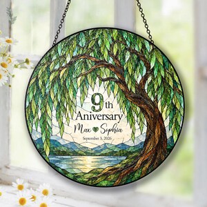 Könnte beinhalten: Ein runder Buntglas-Sonnenfänger mit einer Weide mit grünen Blättern, einem braunen Stamm sowie einem See und Bergen. Der Text lautet 9th Anniversary, Max und Sophia, und September 3, 2026, mit einem kleinen grünen Herz zwischen den Namen.