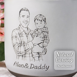 May include: A white ceramic mug with a detailed engraved portrait of a father and child. The text "Alan & Daddy" is below the portrait. The mug also features the text "Natural Carving (No color paint)".