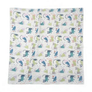 May include: A white textile featuring a repeating pattern of whimsical cats in various poses. The cats are depicted in shades of blue, green, and lavender, with black outlines and curved tails. Small star shapes are scattered throughout the design.