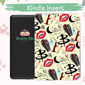 May include: Kindle Insert with a black cover and a patterned case. The case features a repeating design of coffins, vampire fangs, syringes, and the letter "B" on a cream background. The text "Crafty Kia Handmade" is on the black cover.