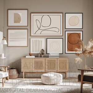May include: A contemporary living room with framed abstract art in neutral colours. The artwork features geometric shapes and line drawings. A wooden cabinet, chairs, and a woven basket complement the decor. The room has a minimalist and modern aesthetic.