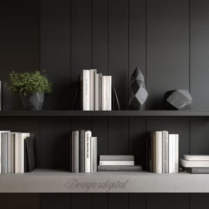 Può includere: Una moderna libreria a due ripiani contro un muro grigio scuro. Il ripiano superiore espone libri, una pianta in vaso e sculture geometriche. Il ripiano inferiore contiene più libri e oggetti decorativi. L'estetica è minimalista e contemporanea.