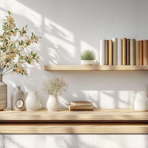 Puede incluir: Una estantería de madera con fondo blanco, que presenta una colección de libros, una planta en maceta y jarrones decorativos con flores. La estantería está hecha de madera clara y tiene un diseño simple y moderno.