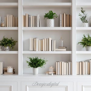 Könnte beinhalten: Weißer Einbauschrank mit Büchern in verschiedenen Größen und Farben. Mehrere Regale zeigen grüne Topfpflanzen und dekorative Gegenstände. Die Gesamtästhetik ist sauber und minimalistisch, mit Fokus auf neutralen Tönen und natürlichen Elementen.