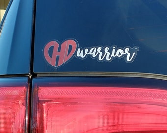 May include: A red heart with the letters "HD" inside and the word "warrior" in white lettering on a black car.