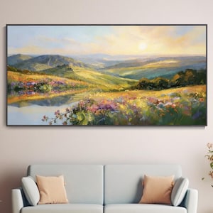 Puede incluir: Una pintura al óleo enmarcada en negro representa un paisaje de valle sereno. La obra presenta colinas verdes onduladas, una masa de agua reflectante y vibrantes flores silvestres bajo una cálida puesta de sol.
