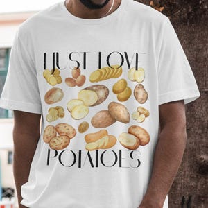 Pode incluir: Camiseta branca com ilustrações de batatas e o texto "I Just Love Potatoes" em preto. As batatas são retratadas inteiras, fatiadas e em cubos, em tons de castanho e amarelo.