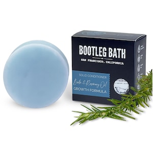 May include: A round, light blue solid conditioner bar with the text "BOOTLEG BATH" and "SAN FRANCISCO, CALIFORNIA" on the box. The box also says "SOLID CONDITIONER" and "Bath & Rosemary Oil GROWTH FORMULA".