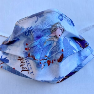 May include: A blue and white face mask with a print of Elsa from the movie Frozen. The mask has the words "Rest spirit" printed on it.