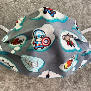 May include: Gray fabric face mask with a repeating pattern of comic book speech bubbles featuring various Marvel superheroes, including Captain America, Iron Man, and Thor. The speech bubbles are in blue and white.
