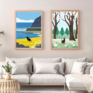 May include: Two framed illustrations of a black cat in different settings. The first illustration shows a cat walking on a yellow field with a blue ocean and a rocky coastline in the background. The second illustration shows a cat walking in a field of white flowers with a green forest in the background.