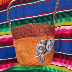 Precioso bolso bandolera de piel marrón con elefante pintado a mano y detalles tejidos