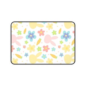 Pode incluir: Um fundo branco com um padrão repetido de coelhos, flores e cenouras em tons pastel rosa, amarelo e azul.