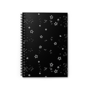 Peut inclure: Un cahier à spirales noir avec un motif d'étoiles et de points blancs. Les étoiles sont soulignées et les points sont petits et dispersés sur la couverture, créant un design céleste.