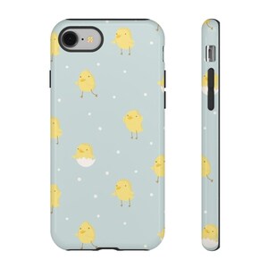 Puede incluir: Una funda para iPhone de color azul claro con un patrón de pollitos amarillos. Algunos de los pollitos están saliendo de los huevos. La funda tiene un borde negro.