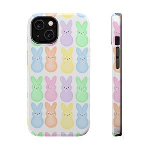 May include: A white phone case featuring a repeating pattern of pastel-colored bunny figures. The bunnies are in shades of blue, pink, yellow, and green. The case has a glossy finish and a black camera lens.