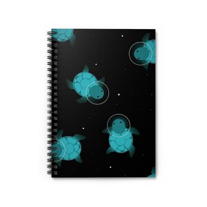 Puede incluir: Una libreta de espiral negra con un patrón repetido de tortugas marinas turquesa en el espacio. Las tortugas están delineadas en blanco y tienen un círculo blanco alrededor de sus cabezas.
