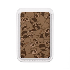 May include: A rectangular phone case featuring a repeating pattern of raccoons in shades of brown and tan. The raccoons have black masks and striped tails. The case has a white border.