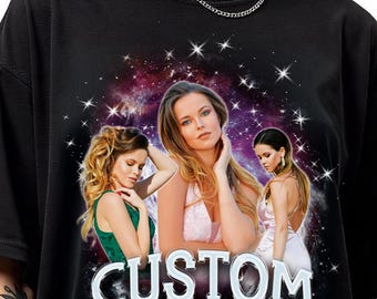May include: Black oversized t-shirt featuring a graphic of three women against a starry galaxy background. The word "CUSTOM" is printed in large, white, stylized letters across the bottom of the graphic.