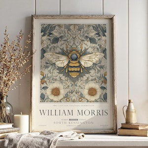May include: A framed print with a detailed illustration of a bee, set against a floral pattern in soft blues and creams. The print displays the text "WILLIAM MORRIS" and details about an 1861 exhibition, with a vintage aesthetic.