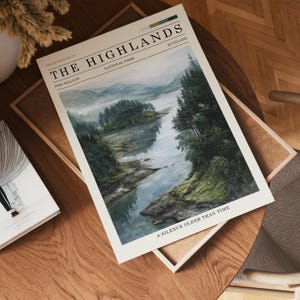 May include: A print depicting The Highlands National Park in Scotland, with a watercolour landscape of a river and forested islands. The print includes the text "A Silence Older Than Time."