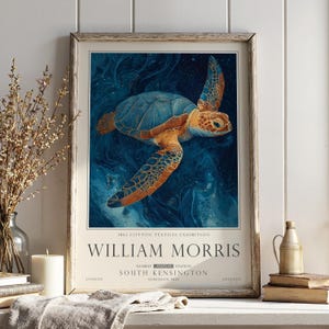 May include: Framed art print of a sea turtle with a blue shell and orange flippers, set against a swirling blue background. The print is an exhibition poster for William Morris, with text at the bottom.