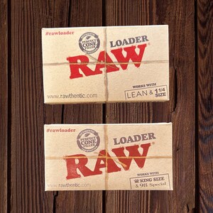 May include: Two boxes of RAW rolling papers, labeled "#rawloader" and "LOADER RAW". The boxes are brown with a red RAW logo and text that says "Authentic Perfect Cone Filler Innovation". The top box says "Works with Lean & 1 1/4 Size". The bottom box says "Works with King Size & 98 Special".