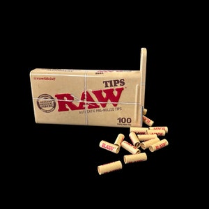 May include: A brown cardboard box with the text "RAW" and "Authentic Pre-Rolled Tips" printed on it. The box contains 100 pre-rolled cigarette tips. The tips are brown and have the word "RAW" printed on them in red.