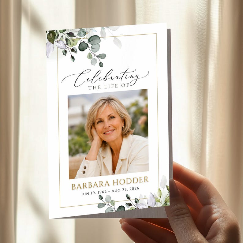 May include: A funeral program card featuring a white background with a gold border and watercolor eucalyptus leaves. The text reads Celebrating The Life Of, Barbara Hodder, and the dates Jun 19, 1962 - Aug 23, 2026, with a central photo.