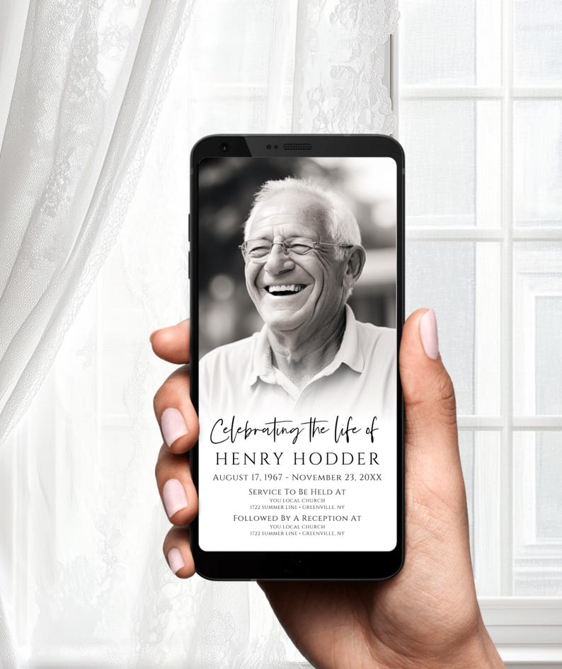以下が含まれることがあります： スマートフォン画面に笑顔の男性の白黒写真。画面には、ヘンリー・ホッダーの追悼式のお知らせも表示されています。1967年8月17日 - 20XX年11月23日。お知らせには、式典とレセプションの場所と時間が記載されています。