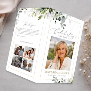 May include: A folded funeral program featuring a white background with green eucalyptus leaf illustrations and gold borders. The front displays a portrait of a woman, the text Celebrating the Life of Barbara Hodder, and dates. The back includes photos.