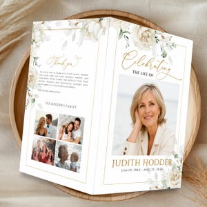 May include: A folded funeral program featuring white floral illustrations with gold accents. The front displays a portrait of Judith Hodder with dates, while the back includes a thank you message, family name, and four smaller photographs of people.