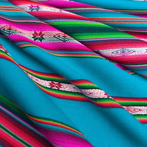 May include: A close-up of a blue fabric with colorful stripes and a woven pattern. The fabric has pink, red, green, and white stripes.