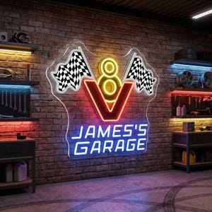 May include: A neon sign for James's Garage, featuring a red and yellow V8 engine design with checkered flags. The sign is mounted on a brick wall, with the text "JAMES'S GARAGE" in blue neon.
